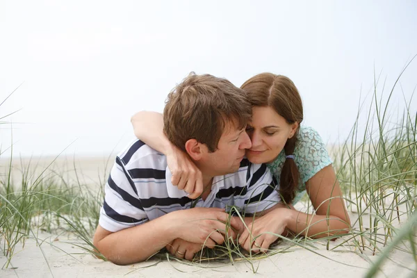 Jovem casal feliz no amor se divertindo em dunas de areia da praia — Fotografia de Stock