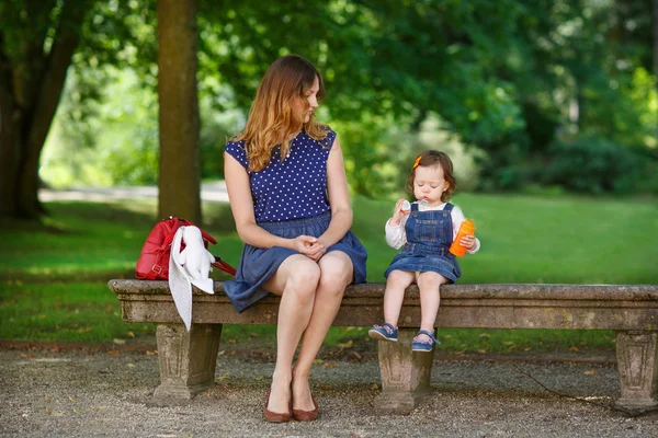 Hermosa madre e hija pequeña caminando en el parque de verano —  Fotos de Stock
