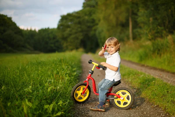 Piccolo bambino ragazzo imparare a cavalcare sulla sua prima moto — Foto Stock