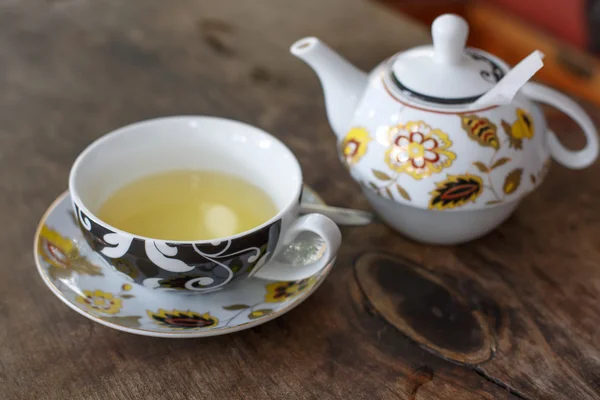 Maceta y taza de té con jazmín sobre fondo de madera — Foto de Stock