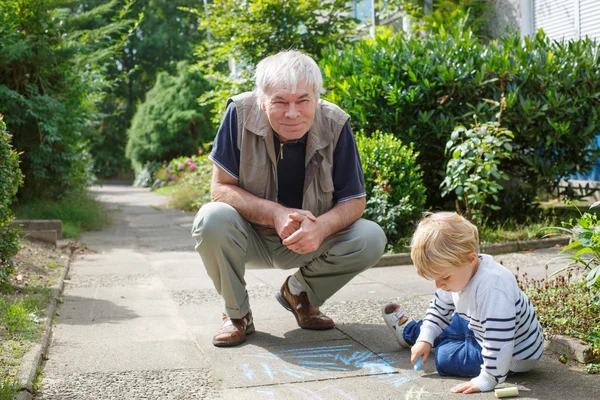 Pequeño niño rubio y feliz abuelo pintando con cha — Foto de Stock