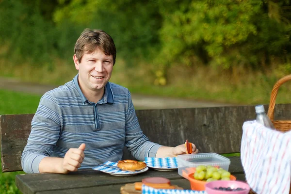 Young man picnicking in the park — Stock Photo, Image