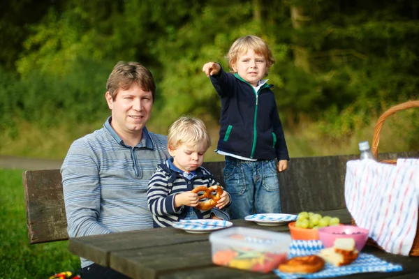 Young father and two little boys picnicking in the park — Stock Photo, Image