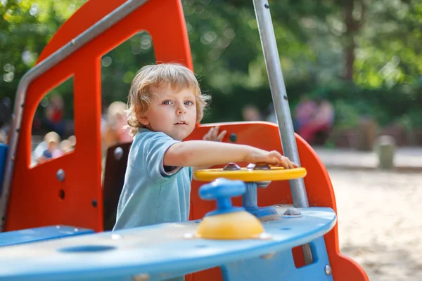 Kleine jongen plezier op stad speeltuin op zonnige dag — Stockfoto