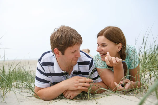 Young happy couple in love having fun on sand dunes of the beach — Stock Photo, Image