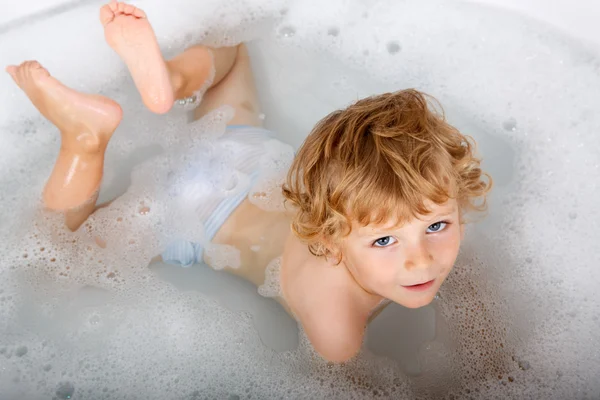 Adorable niño rubio divirtiéndose, tomando un baño en la bañera —  Fotos de Stock