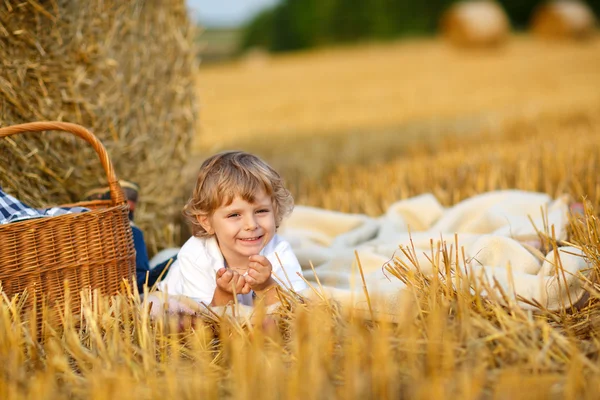 Petit garçon de 3 ans pique-niquer sur champ de foin jaune en été — Photo