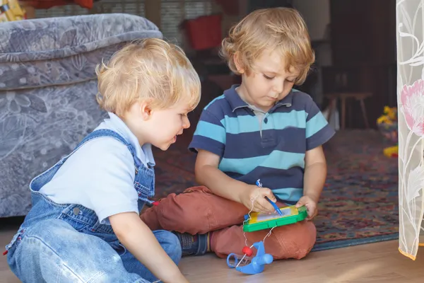 Twee schattige kleine broertje jongen samenspelen binnen — Stockfoto