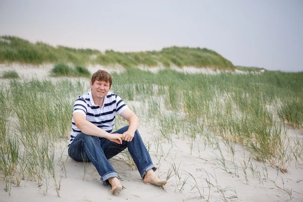 Młody człowiek szczęśliwy, relaks na piaszczystych wydm plaży Normandie — Zdjęcie stockowe