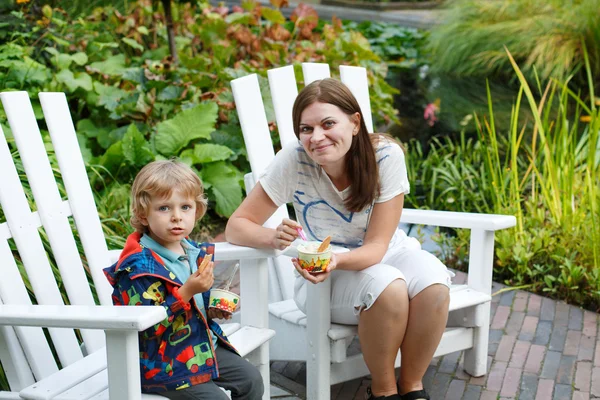 Young woman and little toddler boy eating ice cream outdoors — Stock Photo, Image