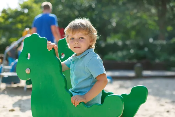 Niño divirtiéndose en el parque infantil de la ciudad en un día soleado — Foto de Stock