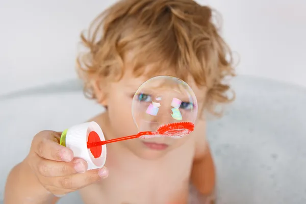 Adorável menino criança loira brincando com bolhas de sabão na banheira — Fotografia de Stock