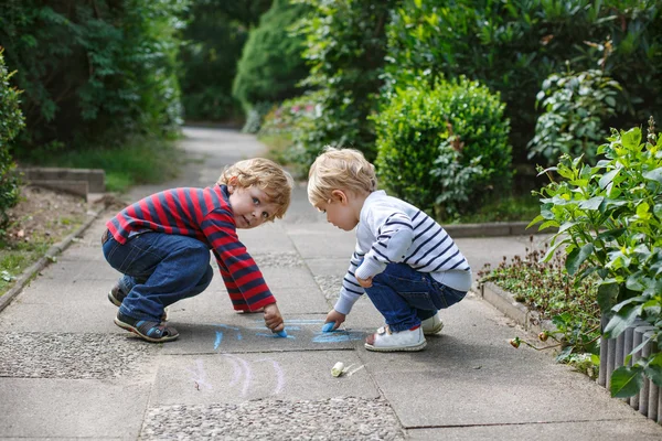 Two little sibling boys painting with chalk outdoors — Stock Photo, Image