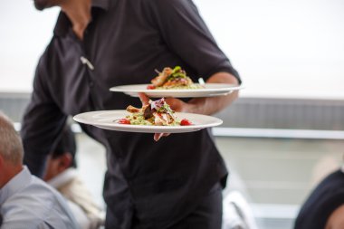 Garson bir tabak salata yemek bir düğün ile taşıma.