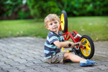 kleine peuter jongen zijn eerste fiets repareren