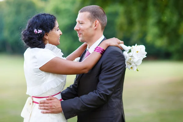 Beautiful indian bride and caucasian groom, in summer park. — Stock Photo, Image
