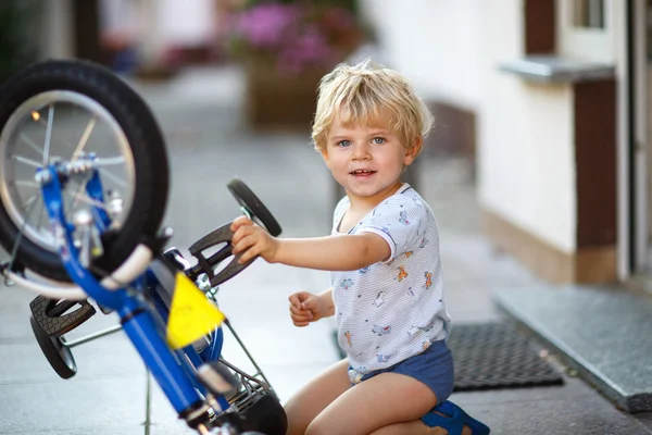 Menino pequeno consertando sua primeira bicicleta — Fotografia de Stock