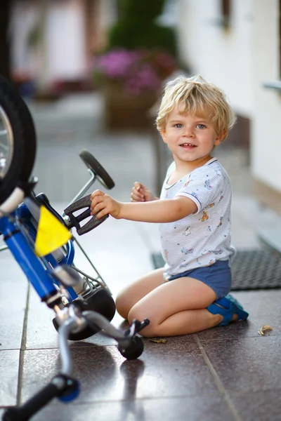 Menino pequeno consertando sua primeira bicicleta — Fotografia de Stock