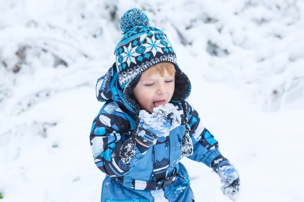 Bedårande barn pojke att ha kul med snö på vinterdag — Stockfoto