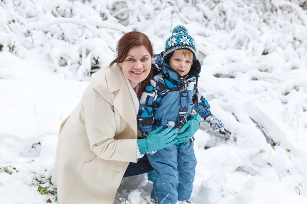 若い女性と彼女の幼い息子に雪を楽しむ冬の fo — ストック写真