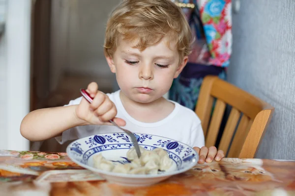 可爱的蹒跚学步的在自家厨房吃面食的三岁的男孩 — 图库照片