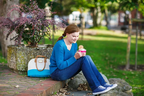 Young woman eating ice cream in summer park. — Stock Photo, Image