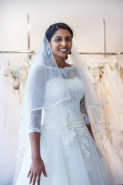 Young indian woman in wedding dress with bridal gowns on display — Stock Photo, Image