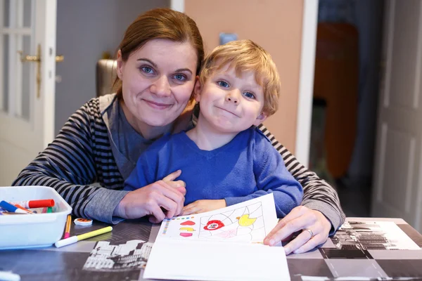 Pequeno menino loiro e sua mãe fazendo juntos homewo pré-escolar — Fotografia de Stock