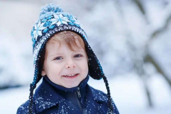 Menino pequeno se divertindo com neve ao ar livre na bela wi — Fotografia de Stock