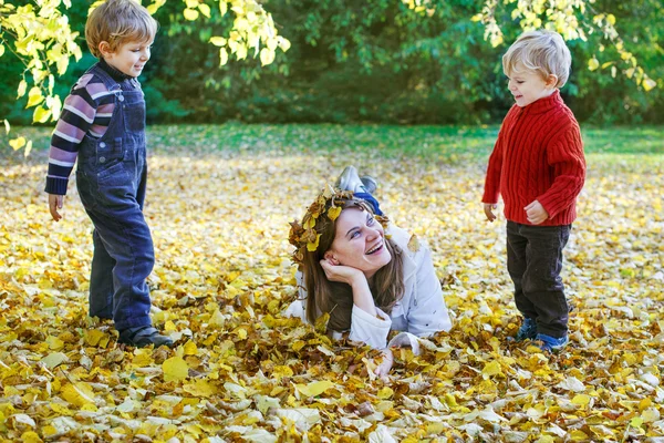 Glückliche Mutter mit kleinem Sohn hat Spaß im Herbstpark. — Stockfoto
