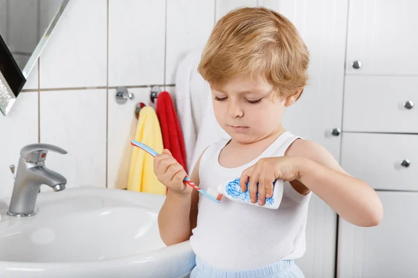 Mooie peuter met blauwe ogen en blond haar zijn tanden poetsen — Stockfoto