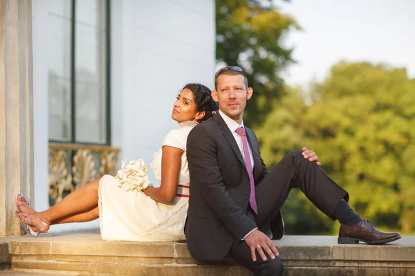 Beautiful indian bride and caucasian groom in park — Stock Photo, Image