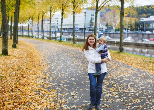 Adorable little son and mother in autumn city. — Stock Photo, Image
