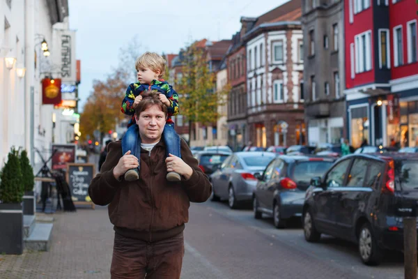 Adorable little son and father walking through city on evening. — Stock Photo, Image