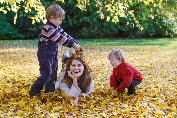 Glad mamma med lille son ha kul i höst park. — Stockfoto