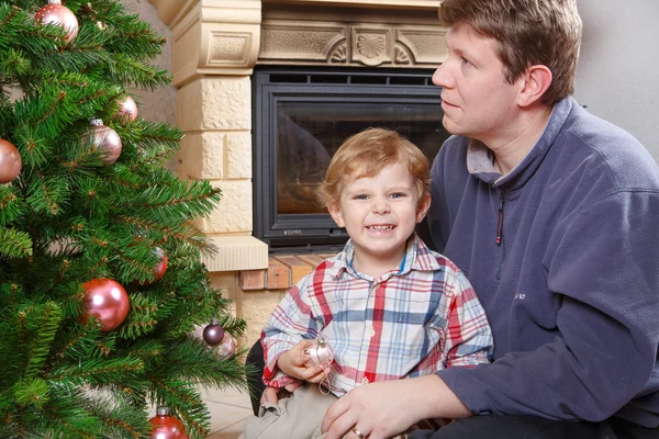 Pappa och lilla sonen dekorera julgran hemma — Stockfoto