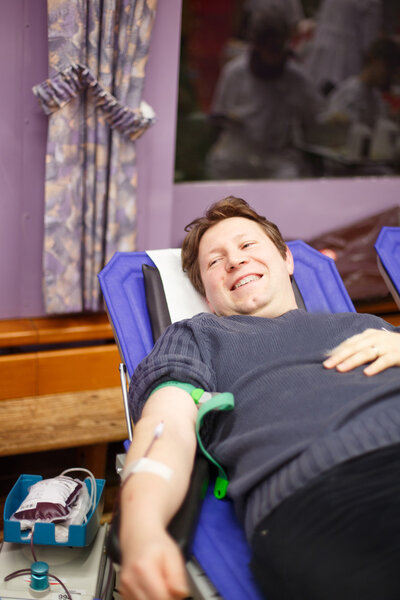 Young happy man donating his blood.