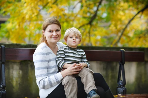 Bedårande lilla son och mor i höstens city. — Stockfoto