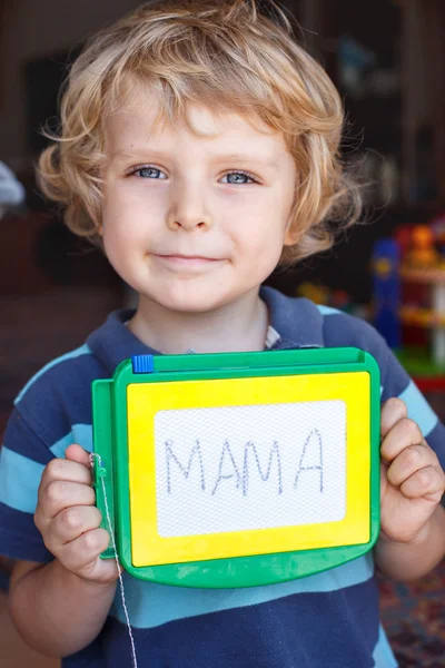 Pequeño niño con tablero de pintura escribe su primera palabra —  Fotos de Stock