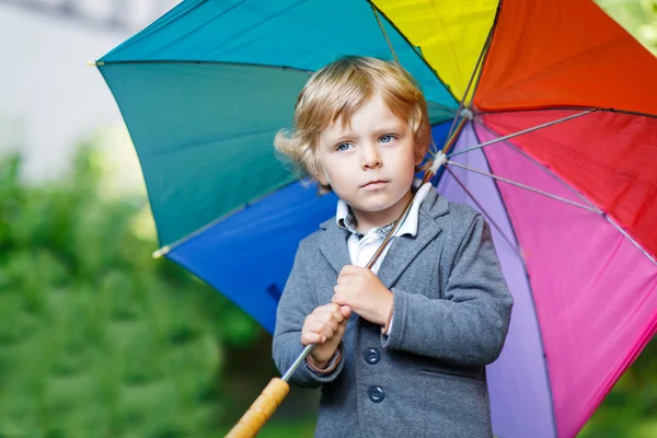 Pequeno menino bonito da criança com guarda-chuva colorido e botas, outdoo — Fotografia de Stock