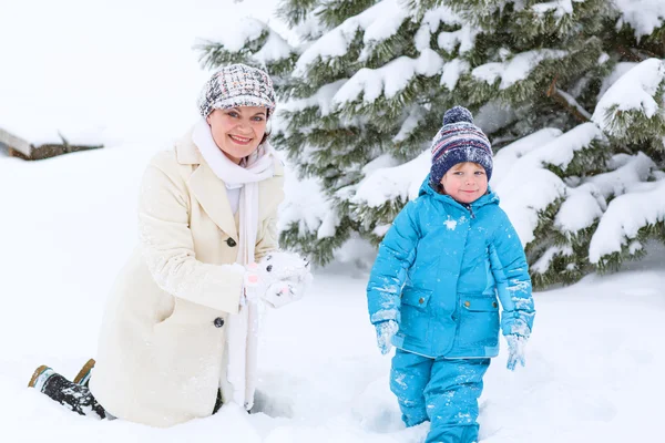 Preschool jongetje en zijn moeder spelen met eerste sneeuw in p — Stockfoto