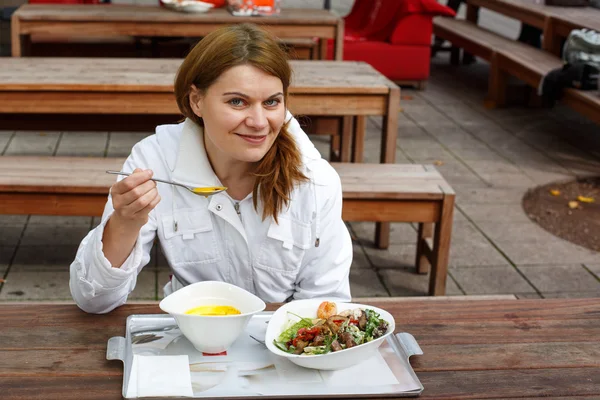 Genç bir kadın açık restoranda yemek, çorba ve salata. — Stok fotoğraf