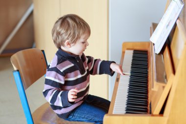 müzik okulunda piyano küçük yürümeye başlayan çocuk.
