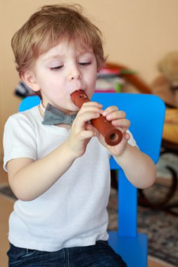 küçük çocuk kapalı tahta flüt çalmaya