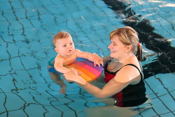 Kleine baby met blauwe ogen leren om te zwemmen — Stockfoto