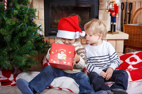 Två små syskon pojkar att vara glad om julklapp — Stockfoto
