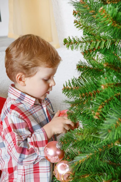 Little blond toddler boy decorating Christmas tree at home — Stock Photo, Image