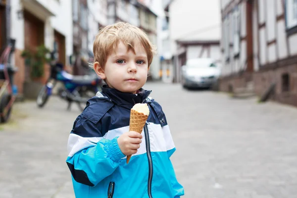 Šťastný roztomilý chlapec jíst zmrzlinu v kuželu. — Stock fotografie