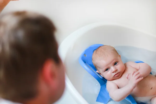 Babyjongen nemen bad en zijn vader kijken op hem — Stockfoto