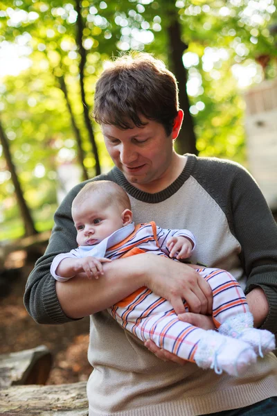 Junger Vater trägt Sohn in Sommerwald — Stockfoto